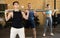 Focused young man in activewear exercising with barbell during group workout in gym health center. CrossFit healthy