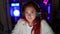 Focused young redhead woman streamer, immersed in a gripping gaming stream in a dark room, sporting serious face, headphones on,