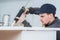 Focused young technician sealing sink in clients kitchen