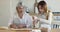 Focused young teenage girl helping cheerful mature grandma to bake