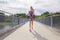 Focused young woman running on bridge over a lake