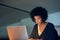 Focusing her efforts on getting the job done. a young businesswoman working late on a laptop in an office.