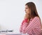 Focussed on absorbing all the information. Profile shot of a young woman sitting at a desk.