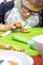 Focussed on the work of the boy`s face with glasses and a kitchen apron, which decorates the cookies using icing in a tube. Beaut