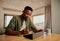 Focussed young adult black African American male writing with pen on electronic tablet while working remotely from