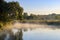 Fog above the river surface on a sunny summer morning. River landscape