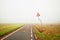 Fog along empty rural road with danger sign
