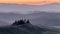 The fog covers the hills of the Val d`Orcia at the first light of dawn, Siena, Tuscany, Italy