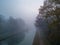 Fog-Enshrouded Canal Path at Dawn