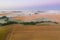 Fog on fields, wind turbines in the background