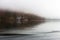 Fog on lake Kenigsee, Germany. Mist on lakeshore with forest reflection in water. Tranquil German landscape with haze.