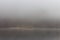 Fog on the lake Kenigsee, Germany. Old wooden house on the bank in fog. Mist on riverbank. German landscape.