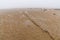 Fog lifting over an endless wadden sea beach at low tide with a mooring rope for boats in the foreground