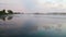 Fog lifts off the lake with dramatic cloudscape at sunrise