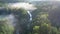 Fog over the river at cold sunrise, aerial view