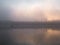 Fog over the river a fisherman in a boat at sunset in November