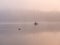 Fog over the river a fisherman in a boat at sunset in November