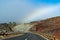 Fog and rainbow descend towards the road between the gorges on the track to the Teide volcano, between the clouds movement, blurry