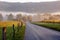 Fog and sun rises on a country lane.