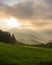 Foggy epic sunrise countryside panorama, valley, hills, field, forest, sun breaking through the clouds