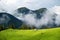 Foggy forest in the mountains. Landscape with field and mist. Landscape after rain. House on the field. A view for the background.