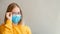 Foggy glasses wearing on young woman. Teenager girl in blue medical protective face mask and eyeglasses wipes blurred foggy misted