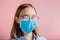 Foggy glasses wearing on young woman. Teenager girl in medical protective face mask and eyeglasses wipes blurred foggy misted