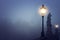 Foggy image of Prague Charles bridge and street lantern at night