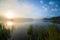 Foggy lakeside at sunrise with tall grass