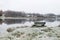 Foggy morning at dawn with forest by the lake, frosted wooden bench by the lake