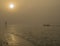 A foggy morning with a lone boatman out at sea at Sandbanks, Dorset