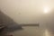 A foggy morning in the port. The boat and the sun