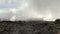 Foggy mountain landscape. Broken stones and boulders. Campground in the distance. Climbing Kilimanjaro, Africa