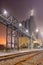 Foggy night scene with rails and pipeline overpass at petrochemical factory