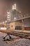 Foggy night scene with rails and pipeline overpass at petrochemical factory