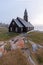 Foggy summer morning in Greenland. The picturesque Ilulissat village on the Greenland Sea shore. Old wooden church in Ilulissat
