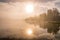 Foggy sunset with forest at long coast line, golden calm lake, Swedish countryside