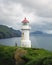 Foggy view of old lighthouse on the Mykines island