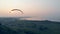 Foggy waterscape and a person floating on the paraglider. Skydiver flies in sky.