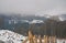 Foggy winter landscape - snowy glade with wood fence and foggy forest landscape in the background