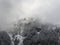 Foggy Winter Mountain. Mountainside Covered by Snow and Trees.