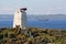 Foghorn on island with passing ship