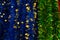 Foil blue green tinsel with golden leaves, backdrop close-up background. Stripes glittering garland polythene foil, Christmas