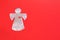 Foil-cut angel figurine on a red background. Place for text about Valentine's Day, love, religion or Angel Day holiday