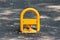 Fold down vehicle security car parking lock safety barrier mounted on paved parking lot surrounded with fallen leaves