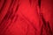 Fold soft waved red velour fabric textured background.