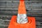 A foldaway car traffic cone isolated on wooden background used as transportation safety, careful driving and road repair concept,