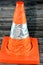 A foldaway car traffic cone isolated on wooden background used as transportation safety, careful driving and road repair concept,