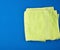 Folded bath terry light green towel on a blue background