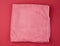 Folded bath terry pink towel on a red background